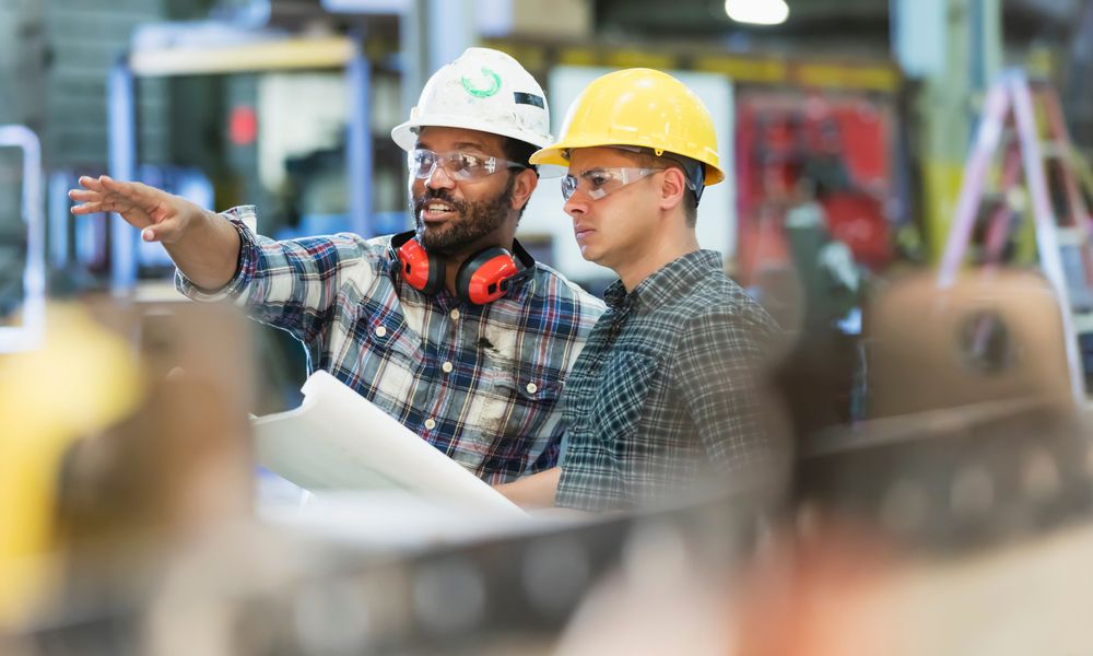 Multi Ethnic Workers Talking In Metal Fabrication Plant